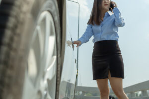 Close up of hand businesswoman opening a car door and call by phone.